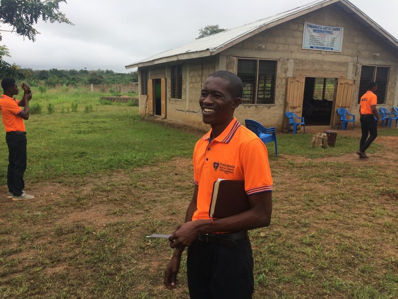 Pastor Rexford Aning. Church building and property in the background.